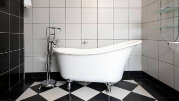 Un baño con bañera independiente, ducha y retrete.