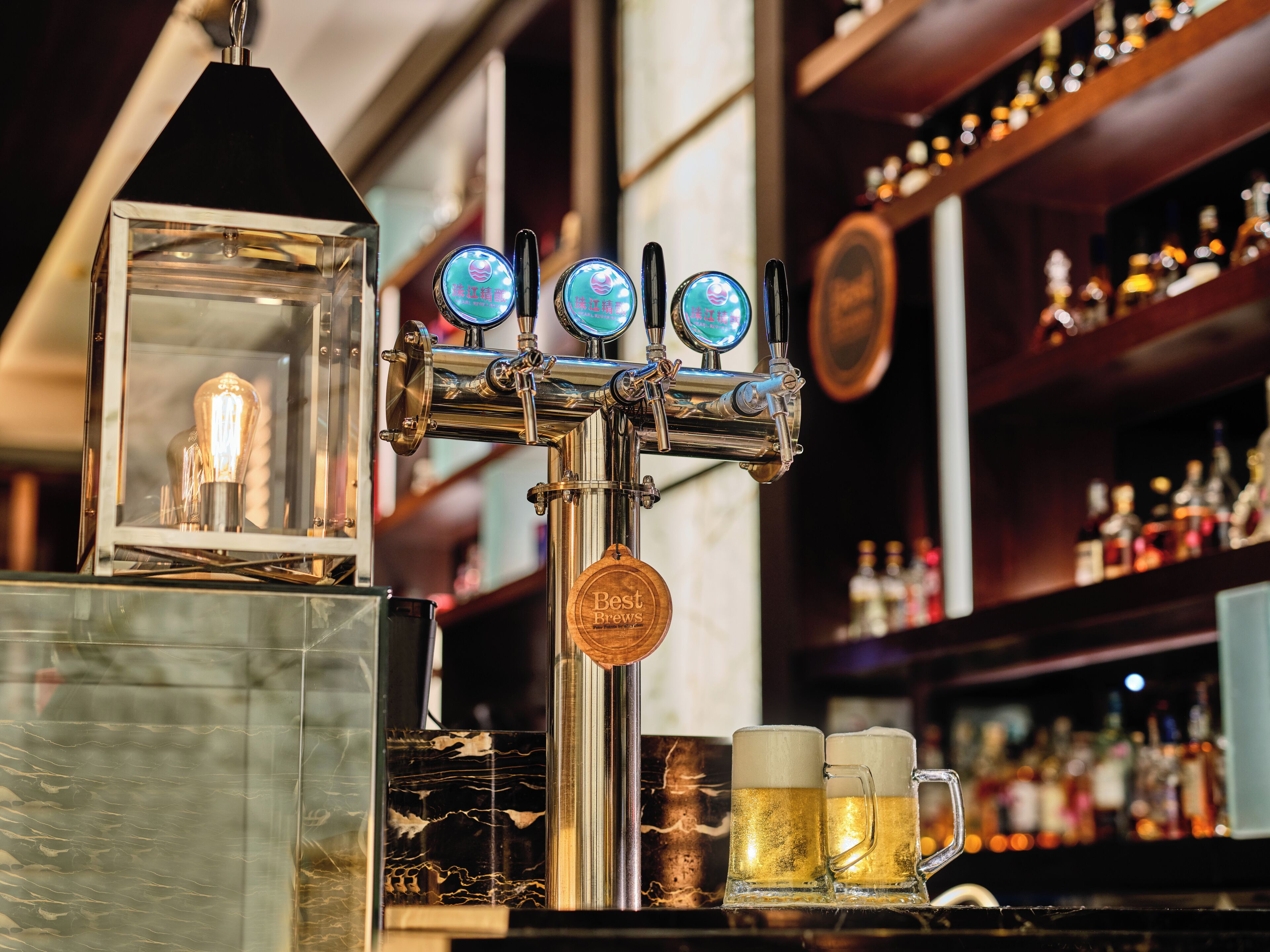 Eine Bar mit Zapfhahn, einer Glaslaterne und einem Kupferbecher.