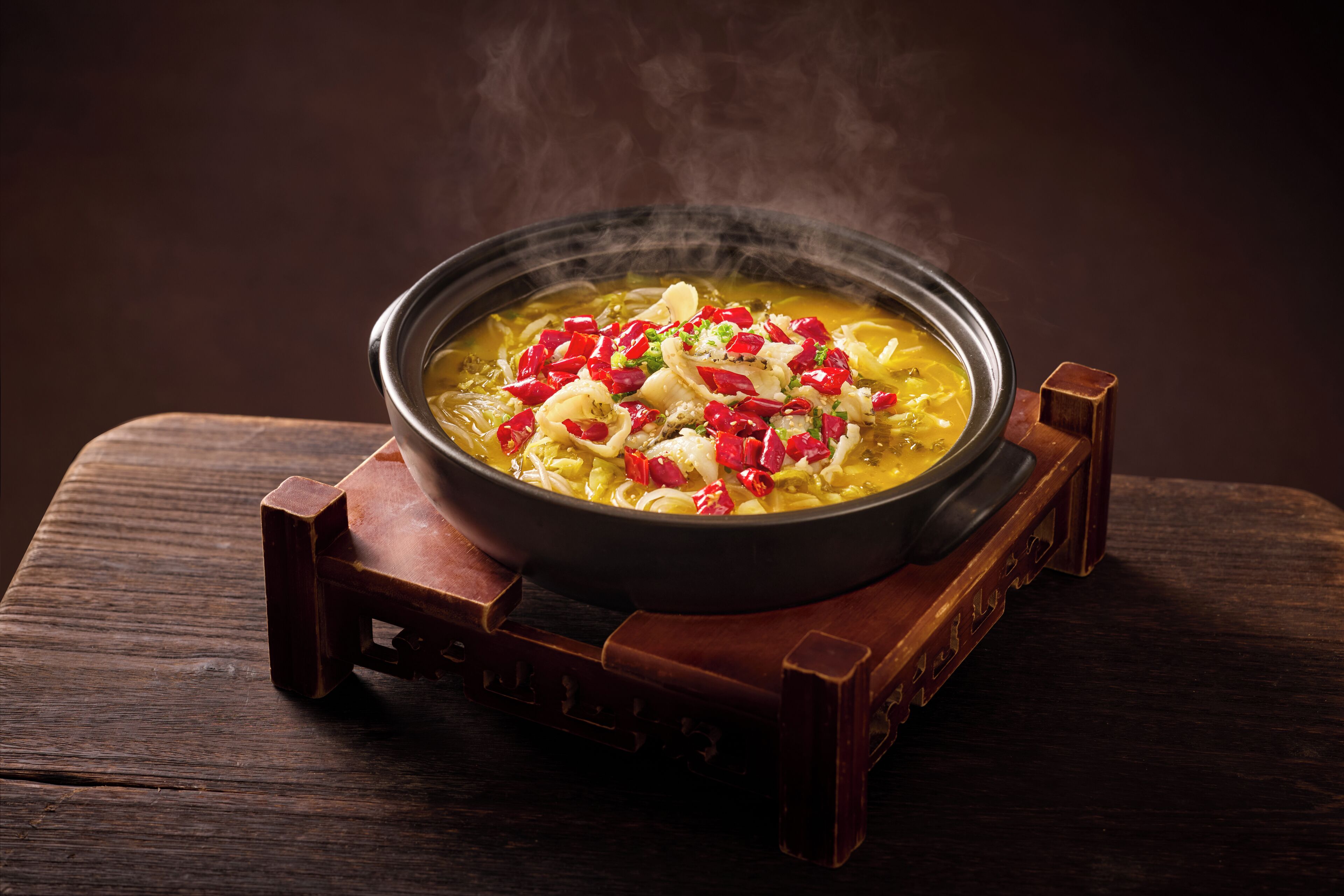 A bowl of soup on a wooden table.