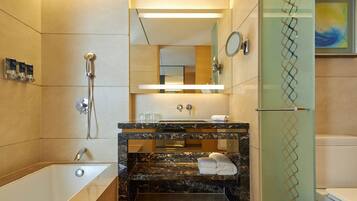 A modern bathroom with a bathtub, a vanity with a mirror, and a shower.