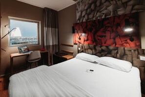 Relax in comfort with a large bed, desk, and city view.