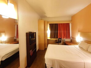 A hotel room with two beds, a desk, a TV, and a chair. - Ibis Manaus Distrito Industrial (Manaus)
