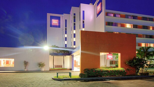 A modern hotel with a prominent 'ibis' sign, a covered entrance, and a brick facade. - Ibis Manaus Distrito Industrial (Manaus)