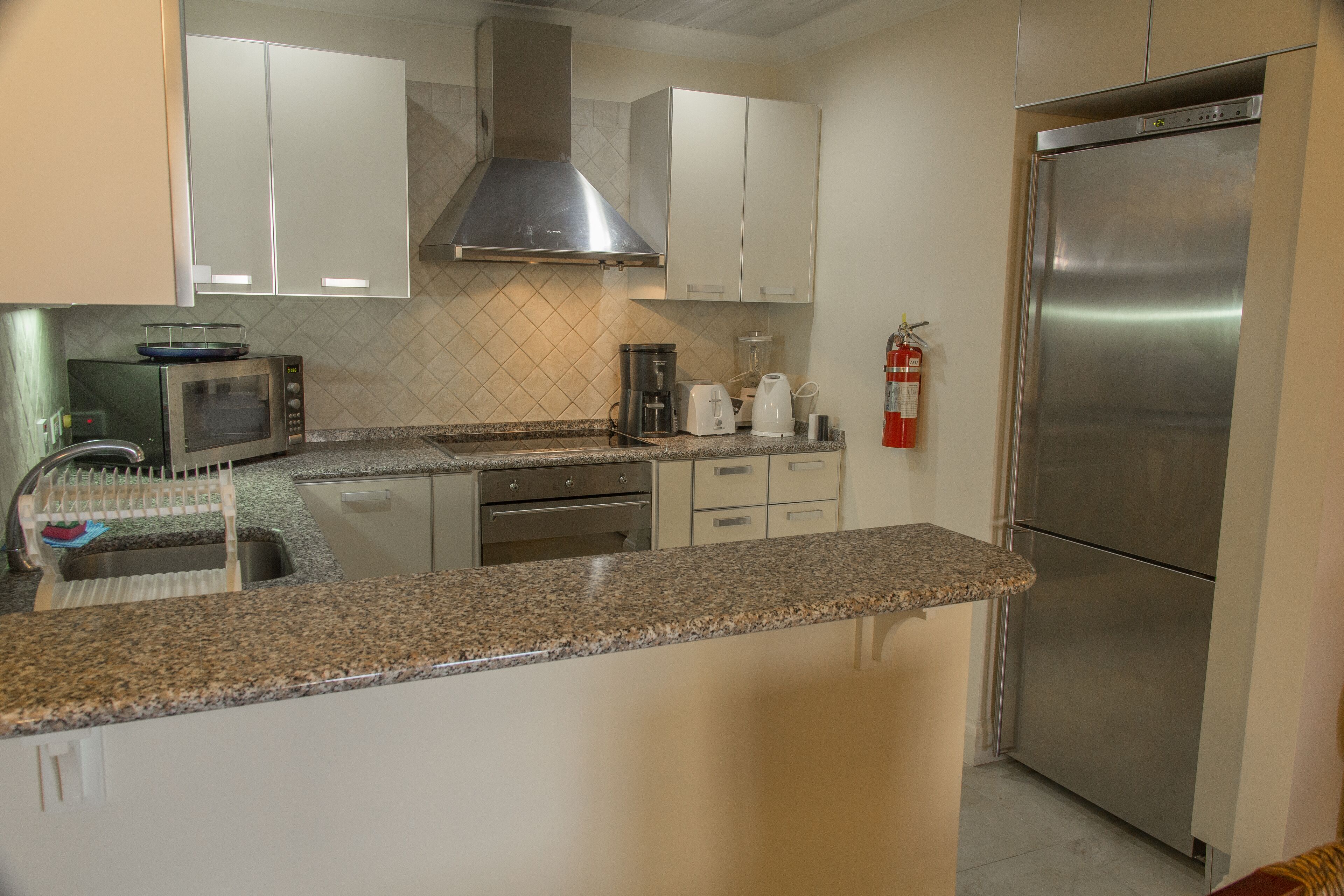 standard condo, 1 king bed, 2 bathrooms, partial ocean view | private kitchen | full-sized fridge, microwave, oven, stovetop