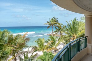 A balcony with a view of a beach and ocean. - White Sands Beach Condos (St. Lawrence Gap)