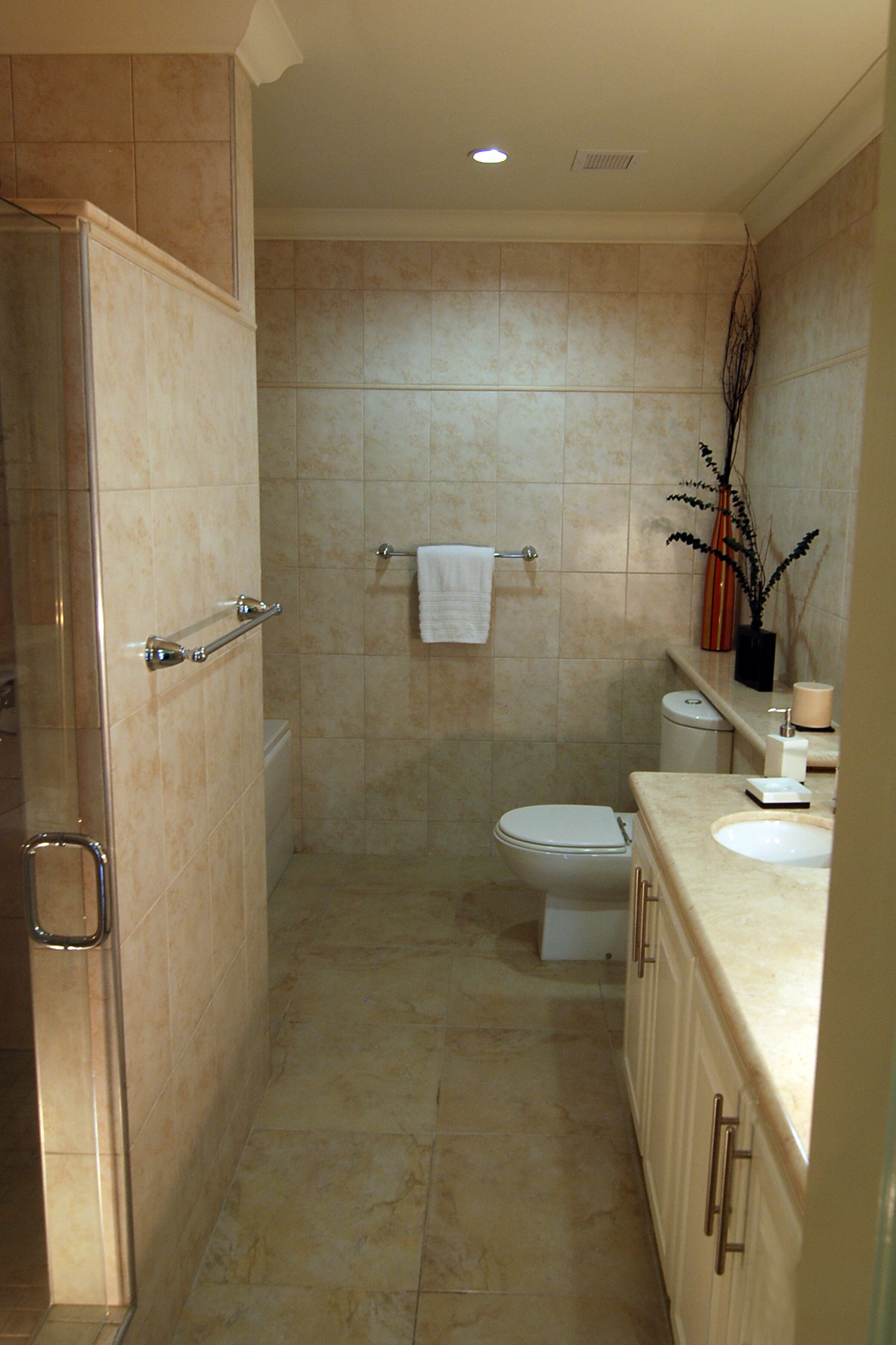 A bathroom with a shower, toilet, sink, and vanity.