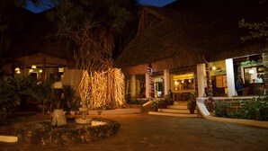 A resort with a thatched-roof building, outdoor seating, and potted plants. - Baobab Sea Lodge (Kilifi)