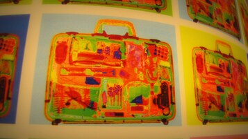 Una pared con varios maleteros de colores.