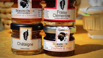 Four jars of Corsica honey labeled 'Domaine Orsini 2024 Calinzana' and 'Fraise Clémentine'.