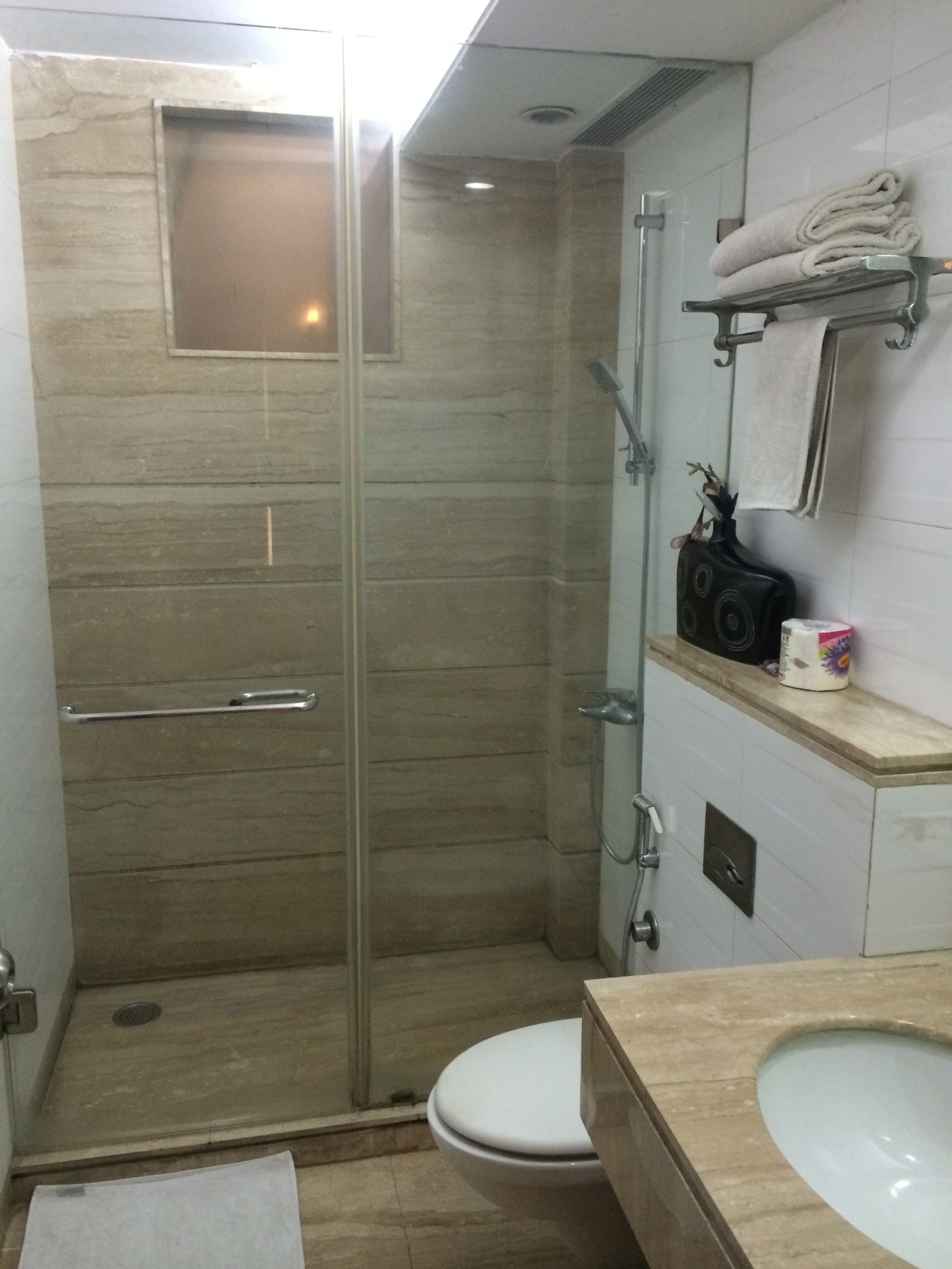 Un baño con ducha de vidrio, inodoro y lavamanos.