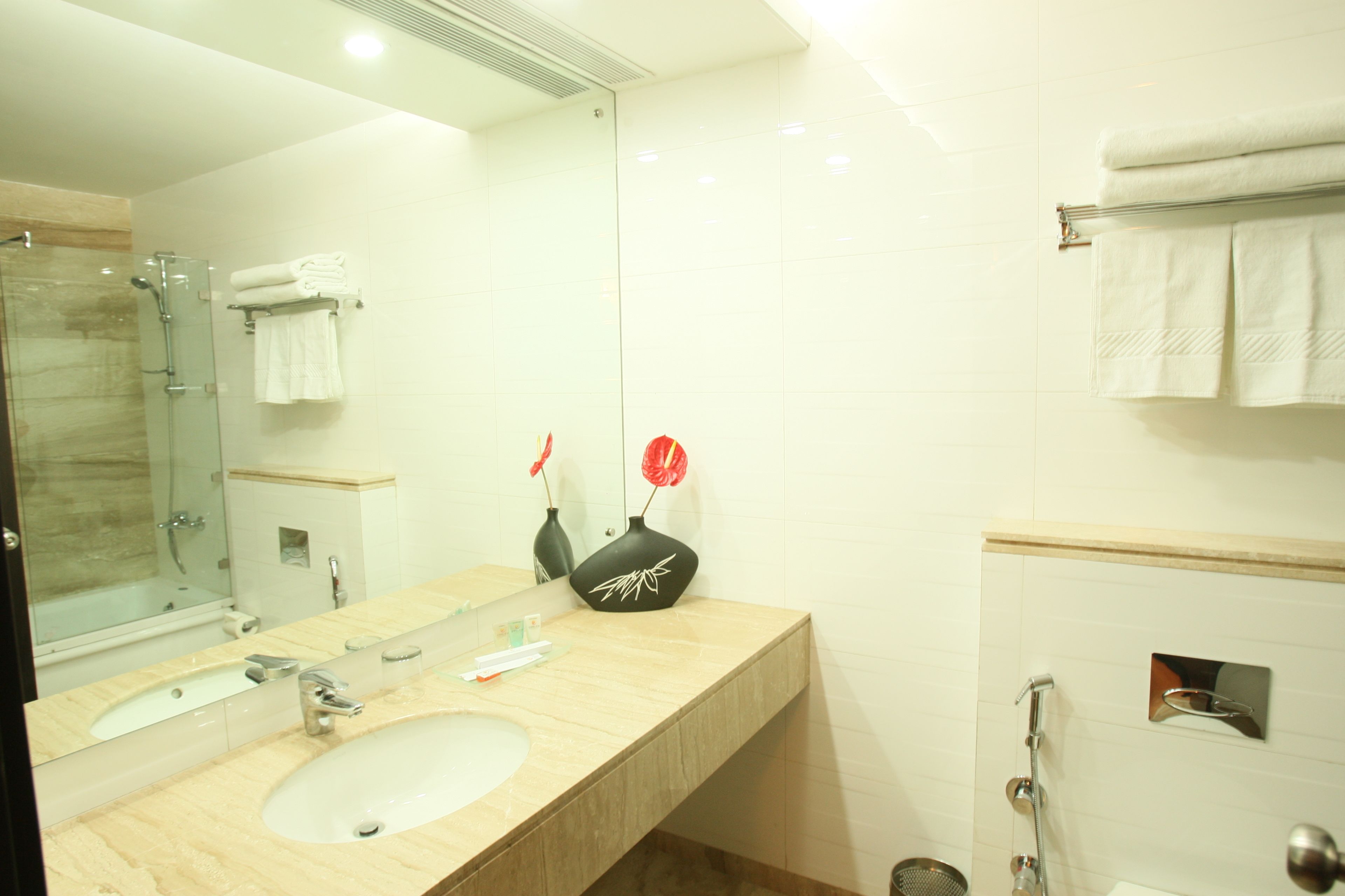 A bathroom with a sink, mirror, and glass shower enclosure.