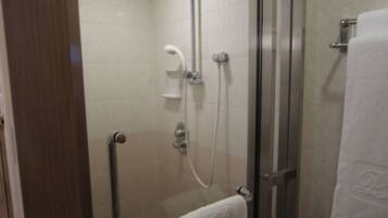 A glass-enclosed shower area with a grab bar, a towel rack, and a showerhead.