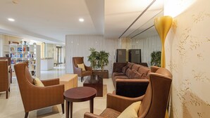 A modern living room with leather sofas, a coffee table, and a bookshelf. - The Residences Vilamoura (Loulé)