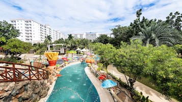 Relax by the vibrant water park with a winding slide, colorful umbrellas, and comfortable seating areas.