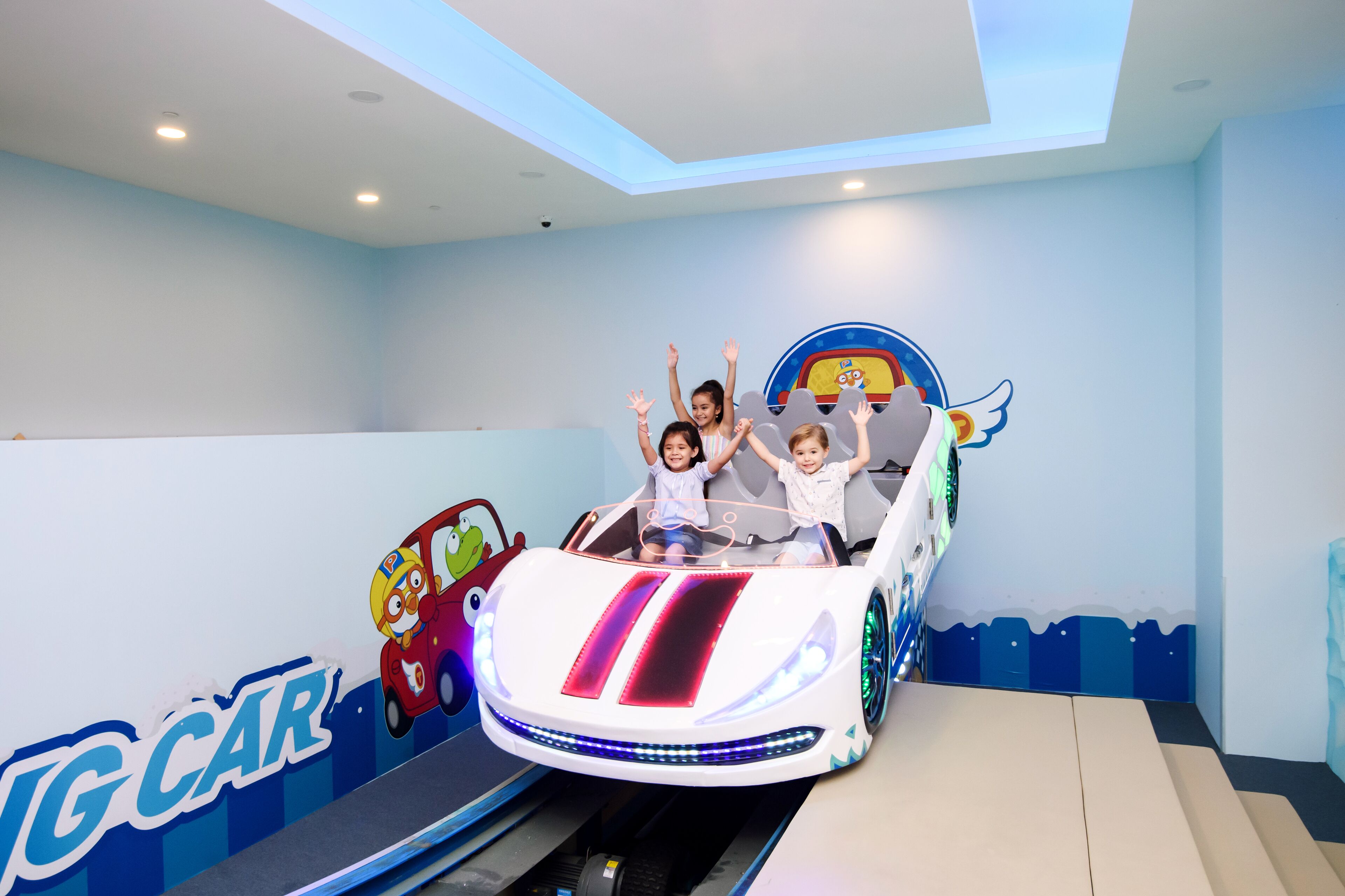 A ride with children seated in a car-shaped vehicle.