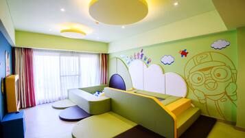 A modern bedroom with a curved bed, built-in seating, and playful wall art.