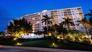 Un hotel de varios pisos con un cartel que dice 'Park Island Resort & Waterpark Cancun'.