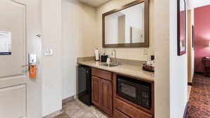 A compact kitchen with a built-in oven, a microwave, and a sink.