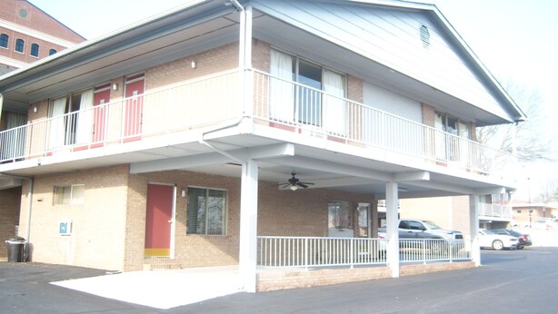 A two-story building with a covered balcony and a single-story extension. - Budgetel Inn and Suites (Rockingham)