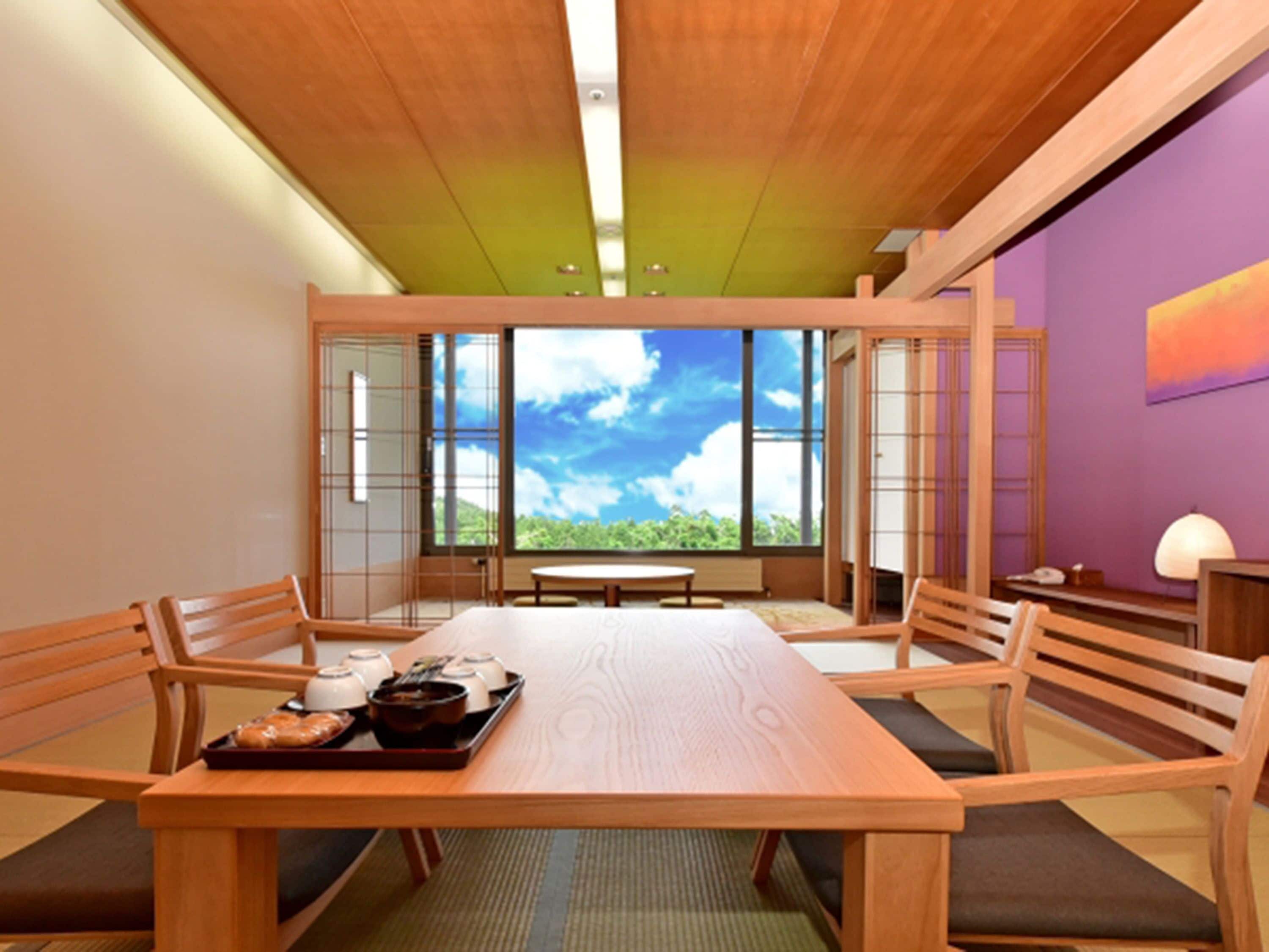 Una habitación tradicional japonesa con una mesa de madera, sillas y vista al cielo a través de amplios ventanales.