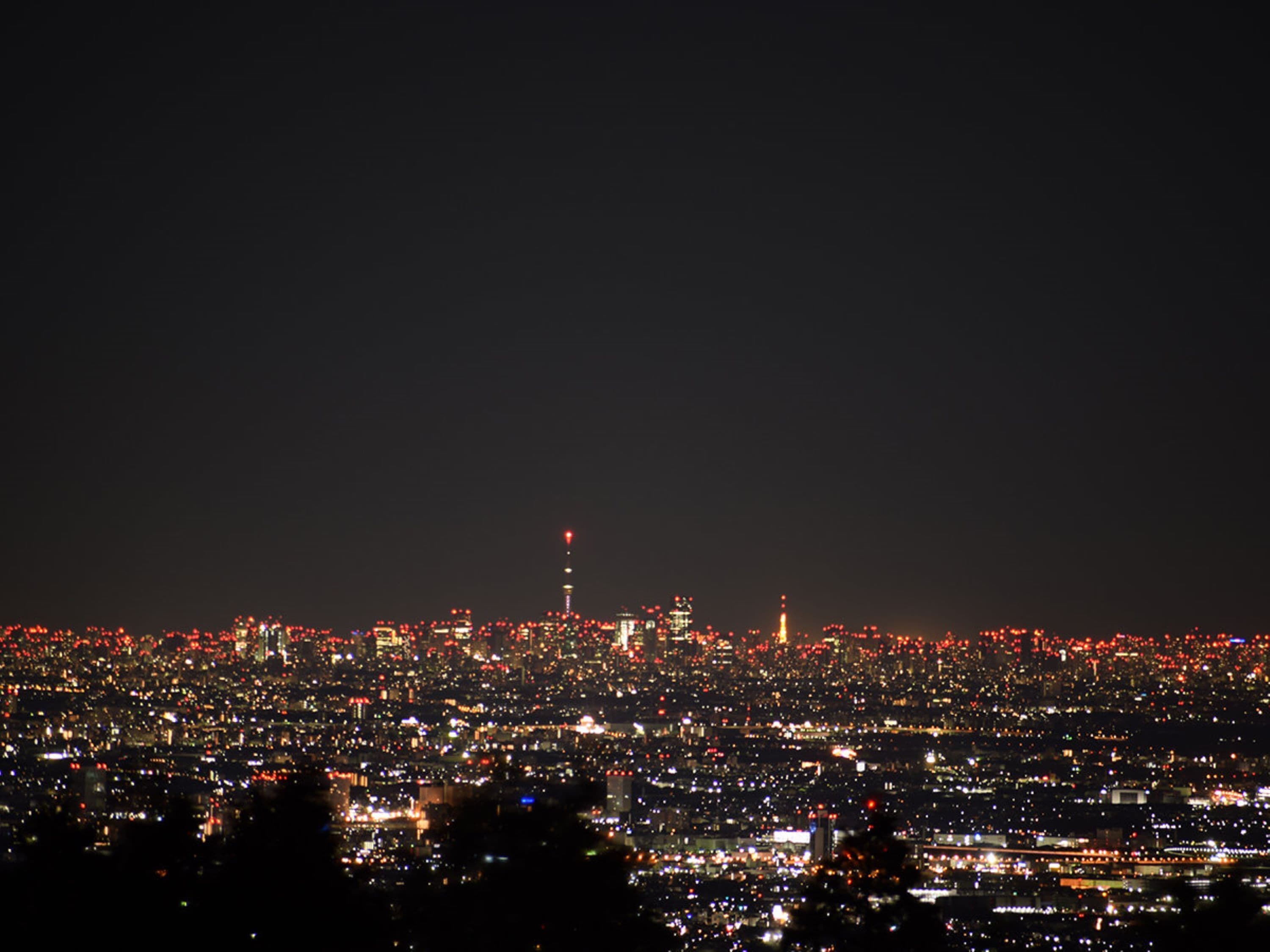 A nighttime cityscape with numerous lights and a prominent tower.