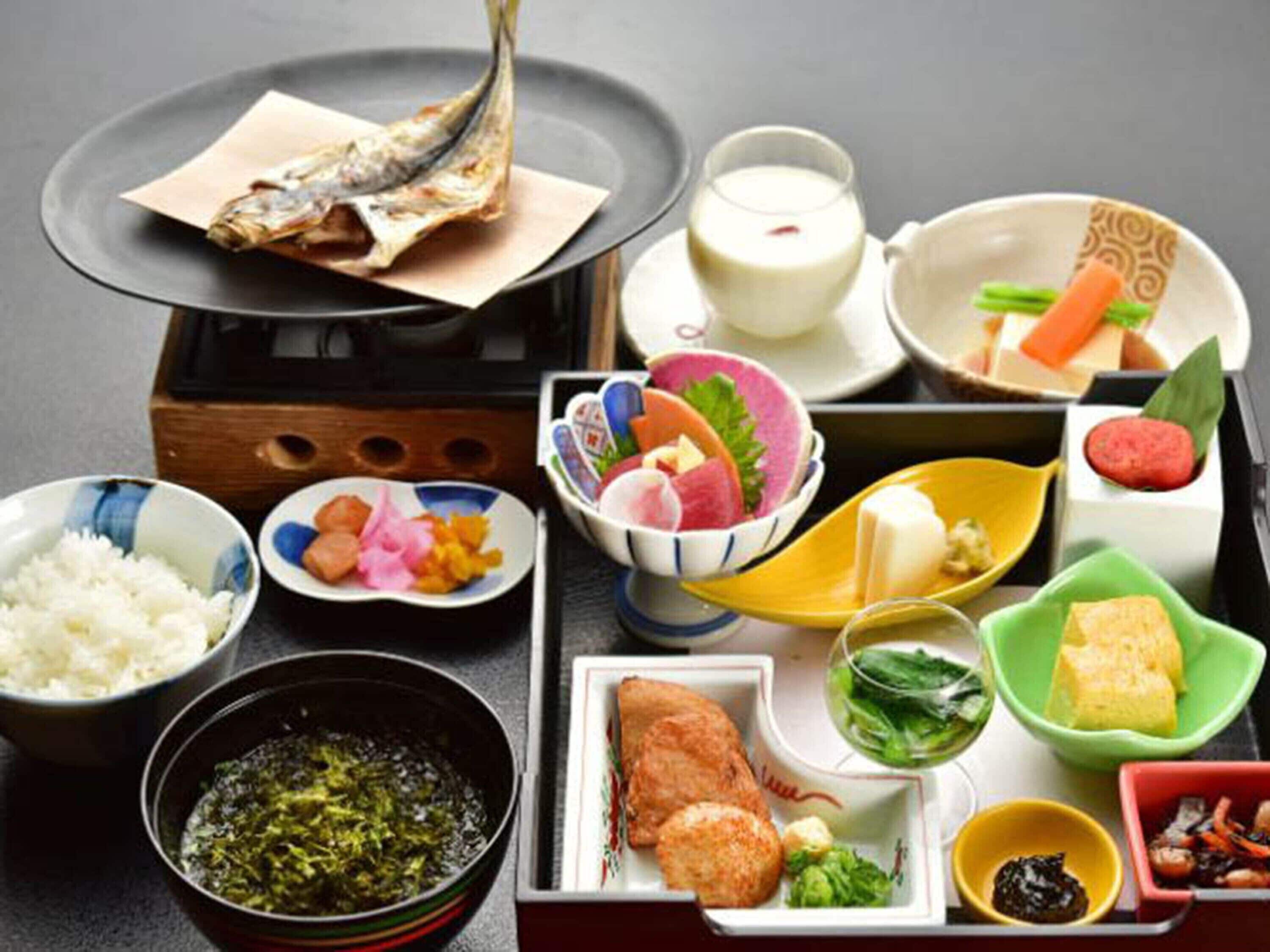 Variedad de platos japoneses, incluyendo sushi, arroz y verduras, dispuestos sobre una mesa.