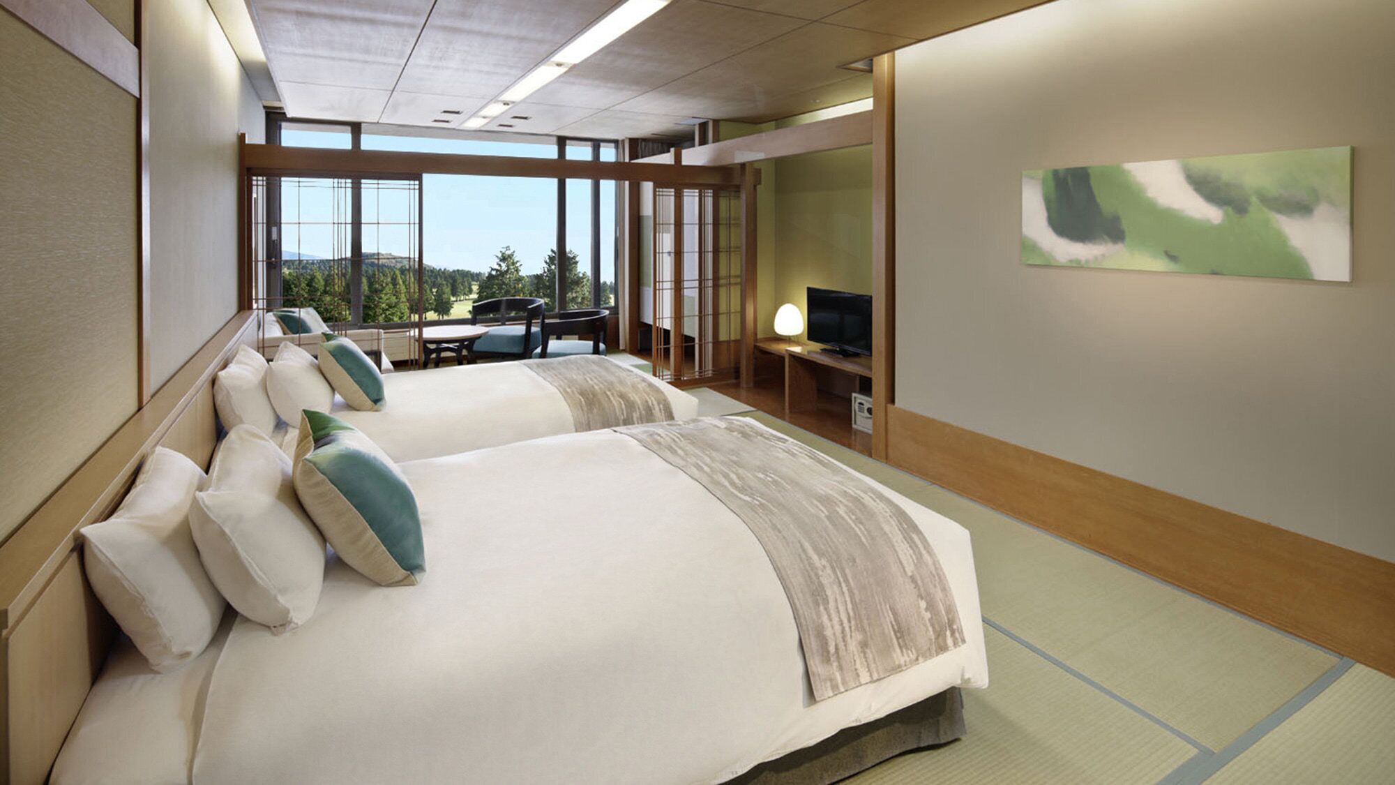 A hotel room with two beds, a TV, a desk, and a view of the outdoors.