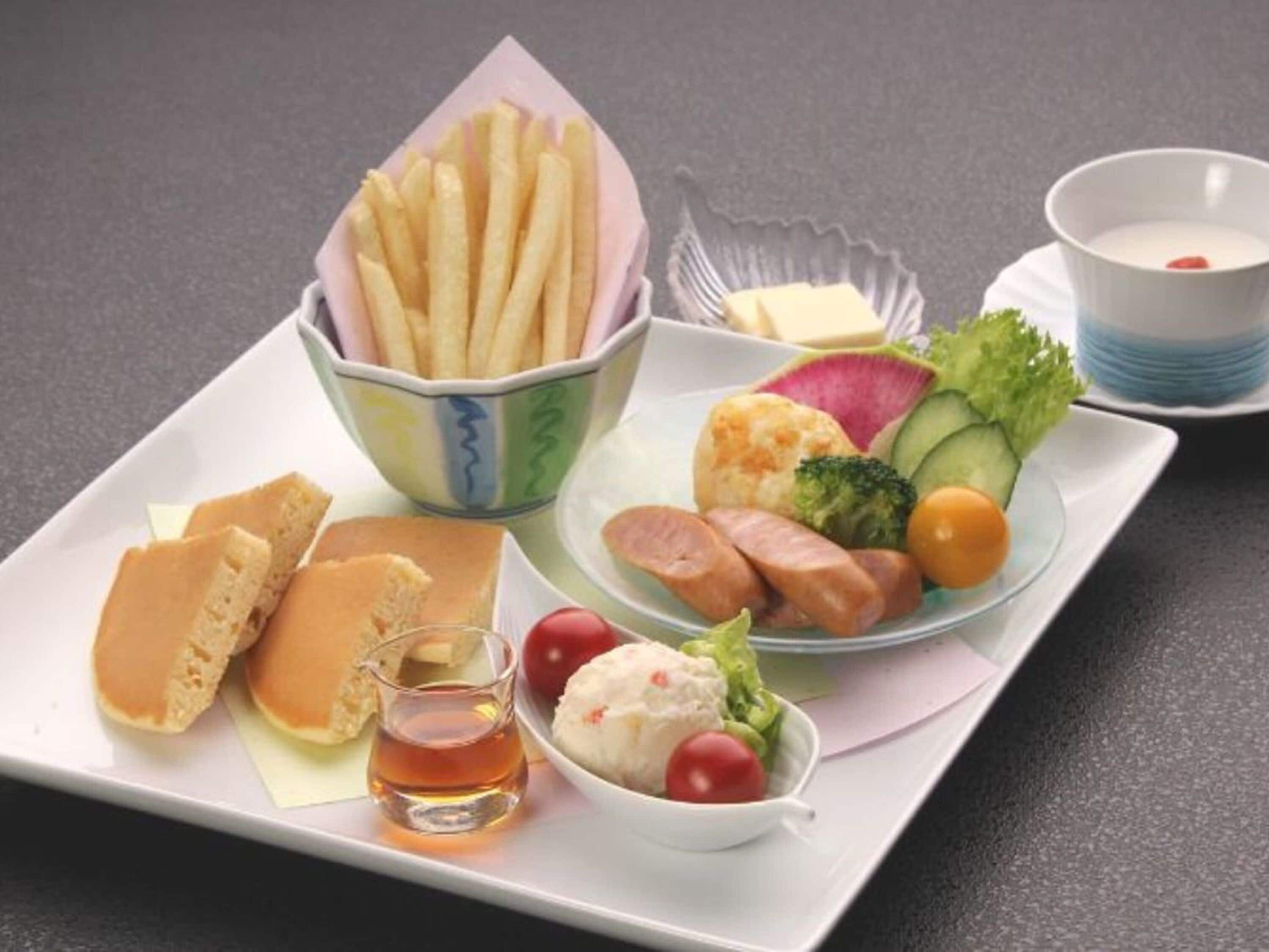 A meal tray with bread, sausages, a small bowl of salad, and a cup of tea.
