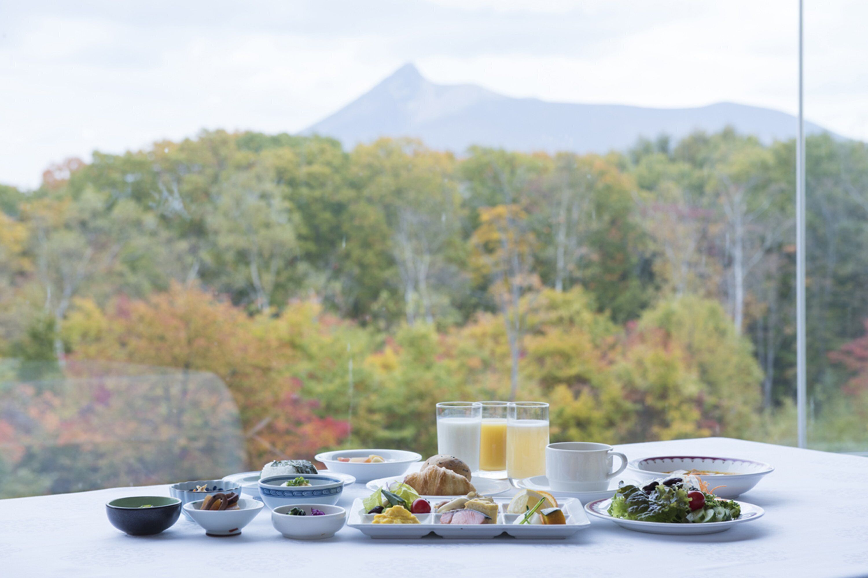 Una mesa con alimentos para el desayuno y una vista a la montaña.