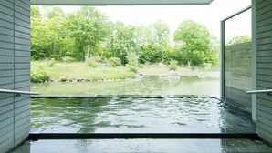 A hot tub area with a view of a pond and trees. - Hakodate Onuma Prince Hotel (Nanae)