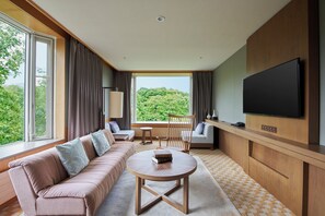 A modern hotel room with a large window, a sofa, a coffee table, and a flat-screen TV. - Hakodate Onuma Prince Hotel (Nanae)