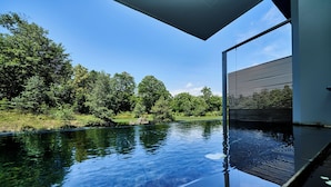 A modern infinity pool with a clear view of a lush green landscape and trees. - Hakodate Onuma Prince Hotel (Nanae)
