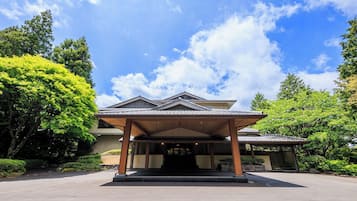 Un edificio tradicional japonés con un porche cubierto y un jardín.