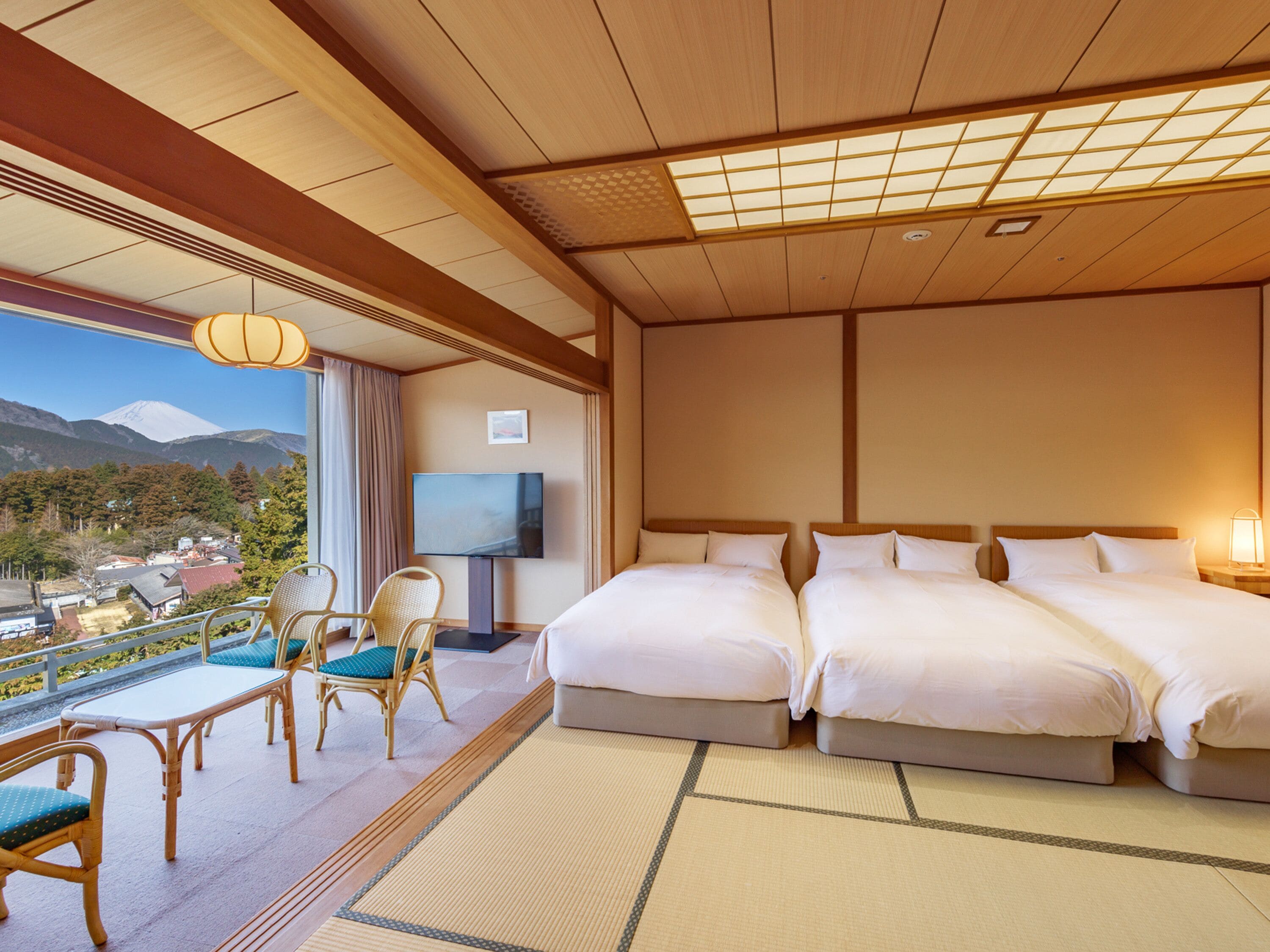 Une chambre d’hôtel avec deux lits, une télévision et une vue sur les montagnes.