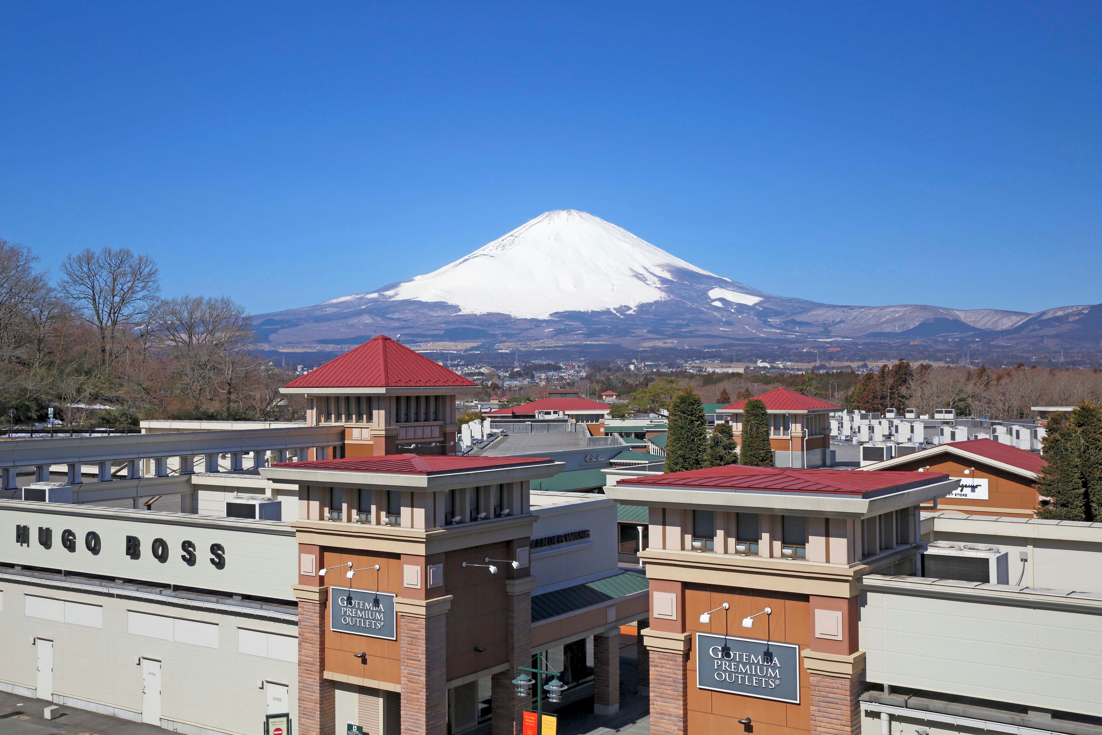 A hotel with a red roof and a sign reading "Hugo Boss" in front.