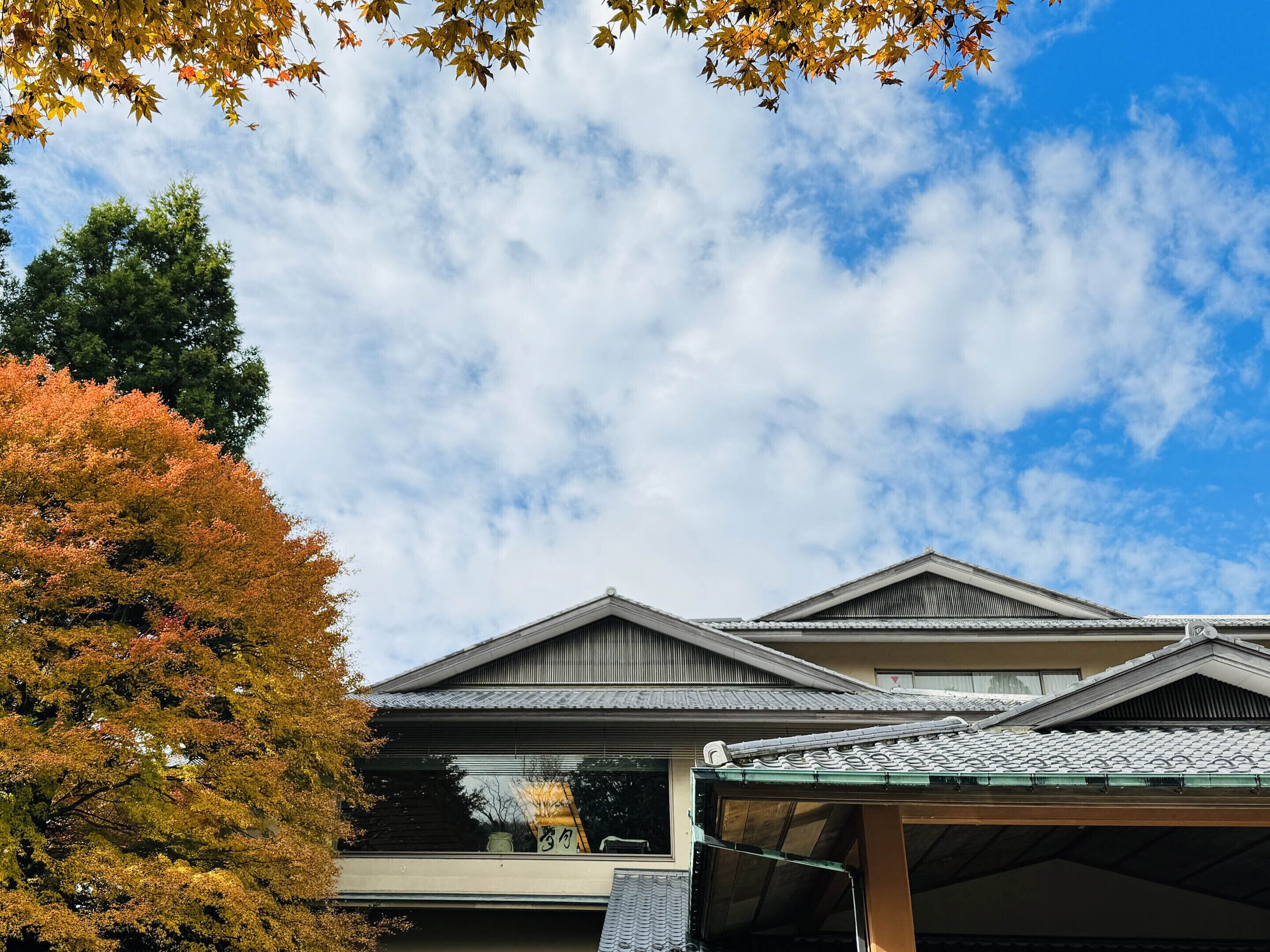 Ein traditionelles japanisches Gebäude mit einem Ziegeldach und einem überdachten Eingang.