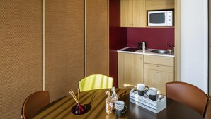 A compact kitchen with a microwave, sink, and wooden cabinets.