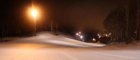 A snow-covered road at night with streetlights.