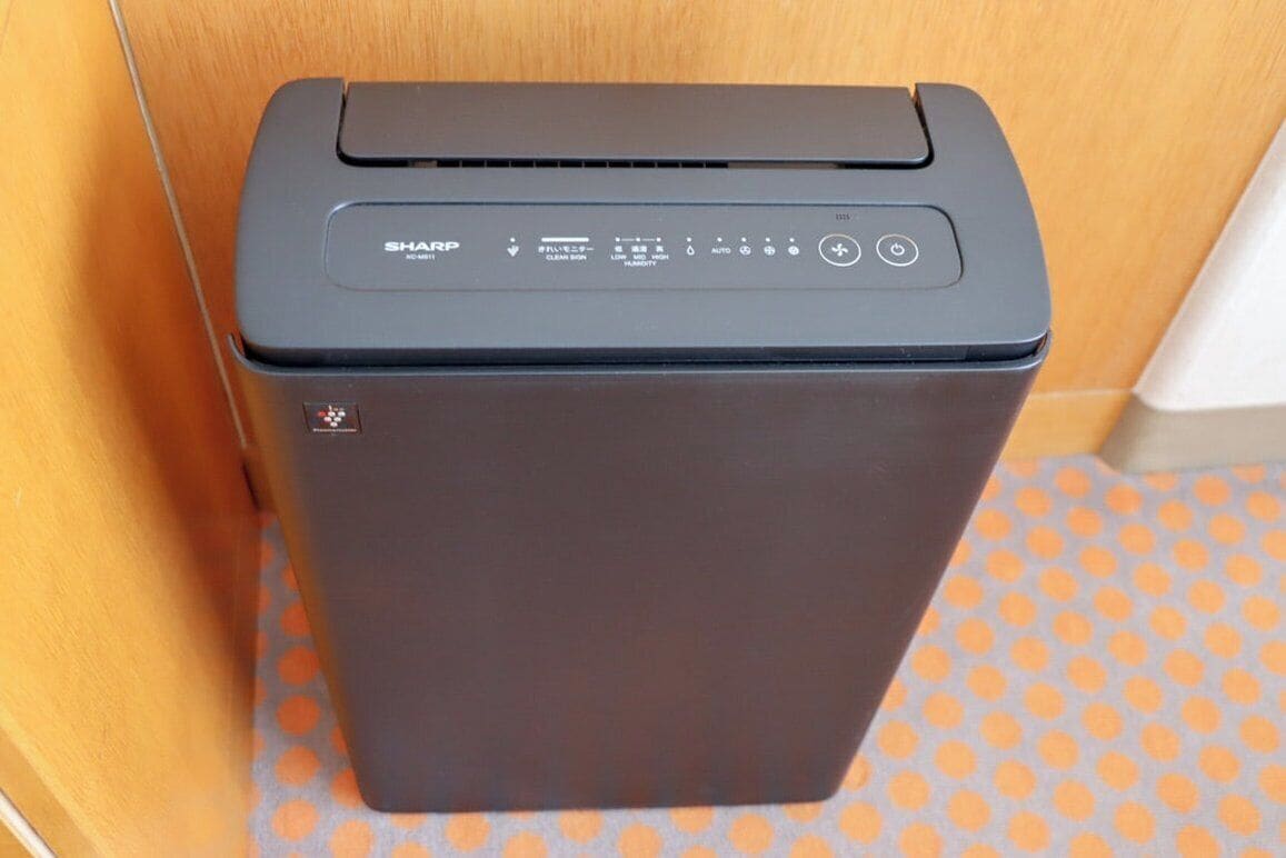 A black Sharp copier with a control panel, placed on a patterned orange and gray floor.