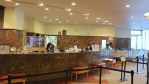 A reception area with a marble counter, seating, and a clock on the wall.