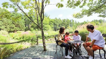 Family gathers on a tranquil outdoor deck surrounded by lush greenery.