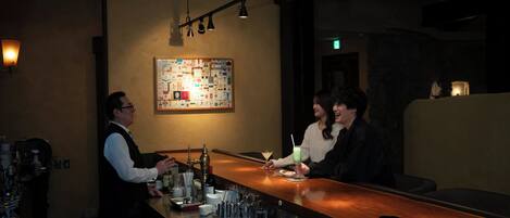 A bar area with a bartender, a menu board, and a seating area.