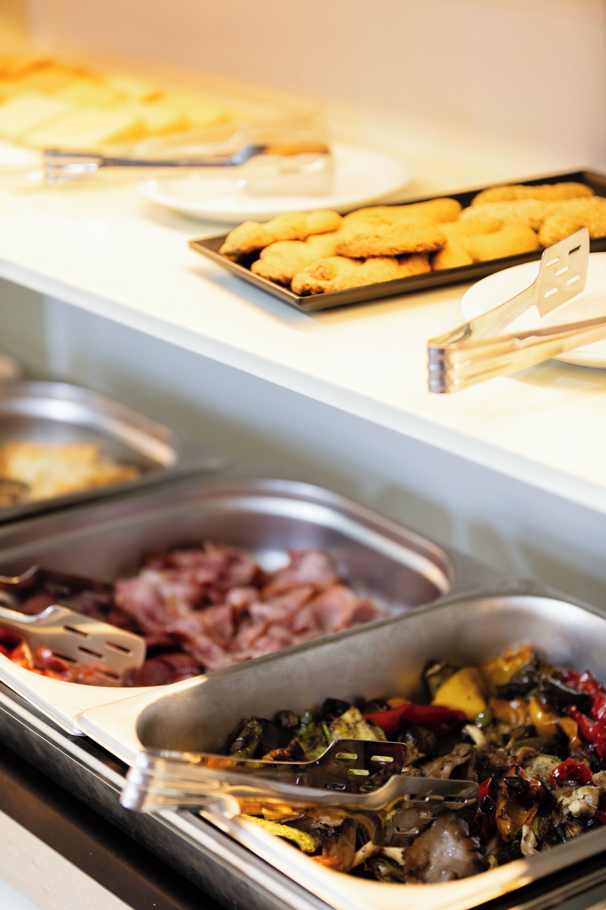 Un bufé con diferentes opciones de comida, como galletas, vegetales y carnes.