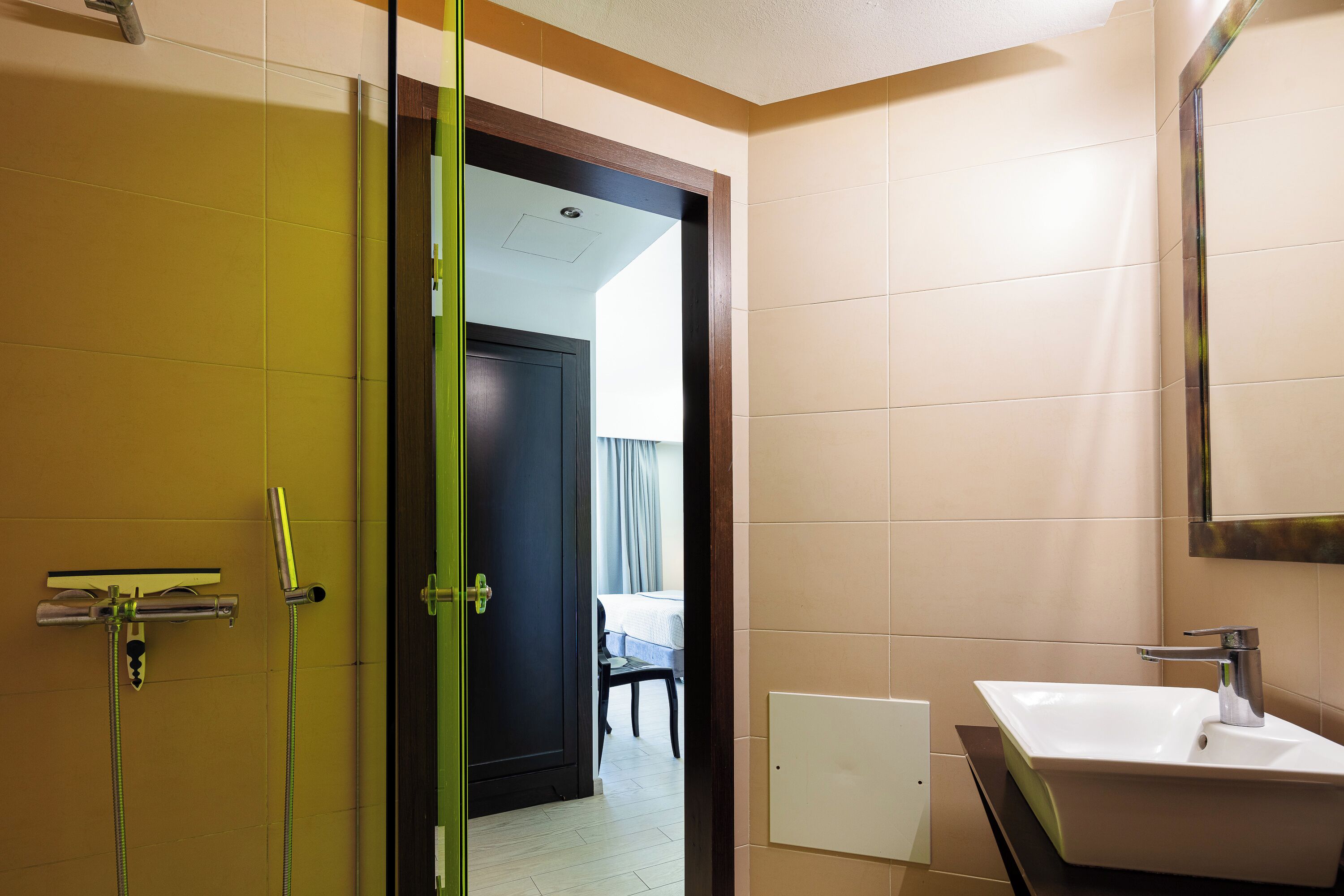 Une salle de bain avec une douche, un lavabo et un miroir.