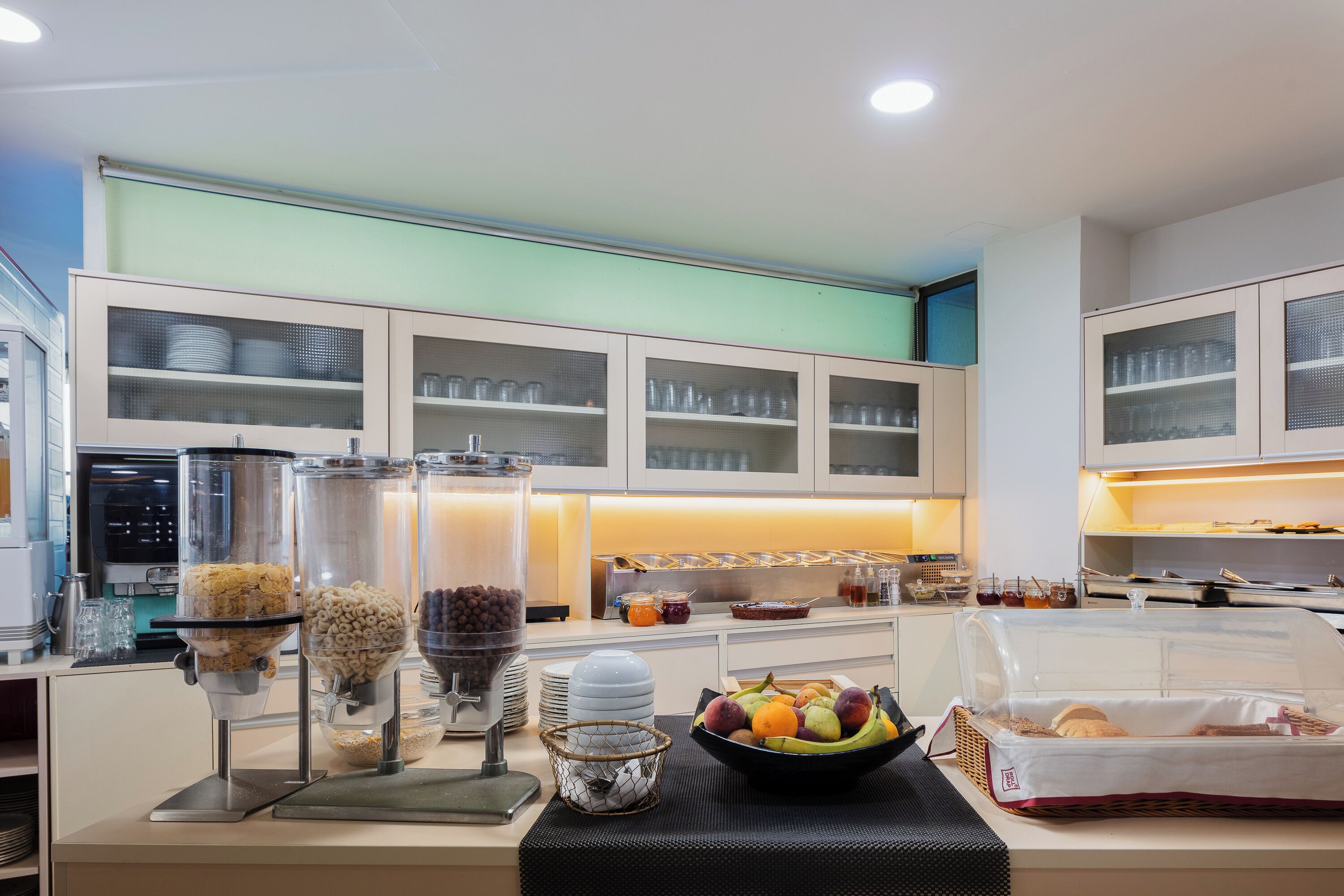 A breakfast buffet area with various food items and a coffee machine.