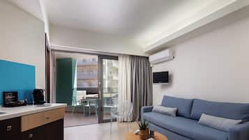 A modern living room with a sofa, a coffee machine, a TV, and a sliding glass door leading to an outdoor area.