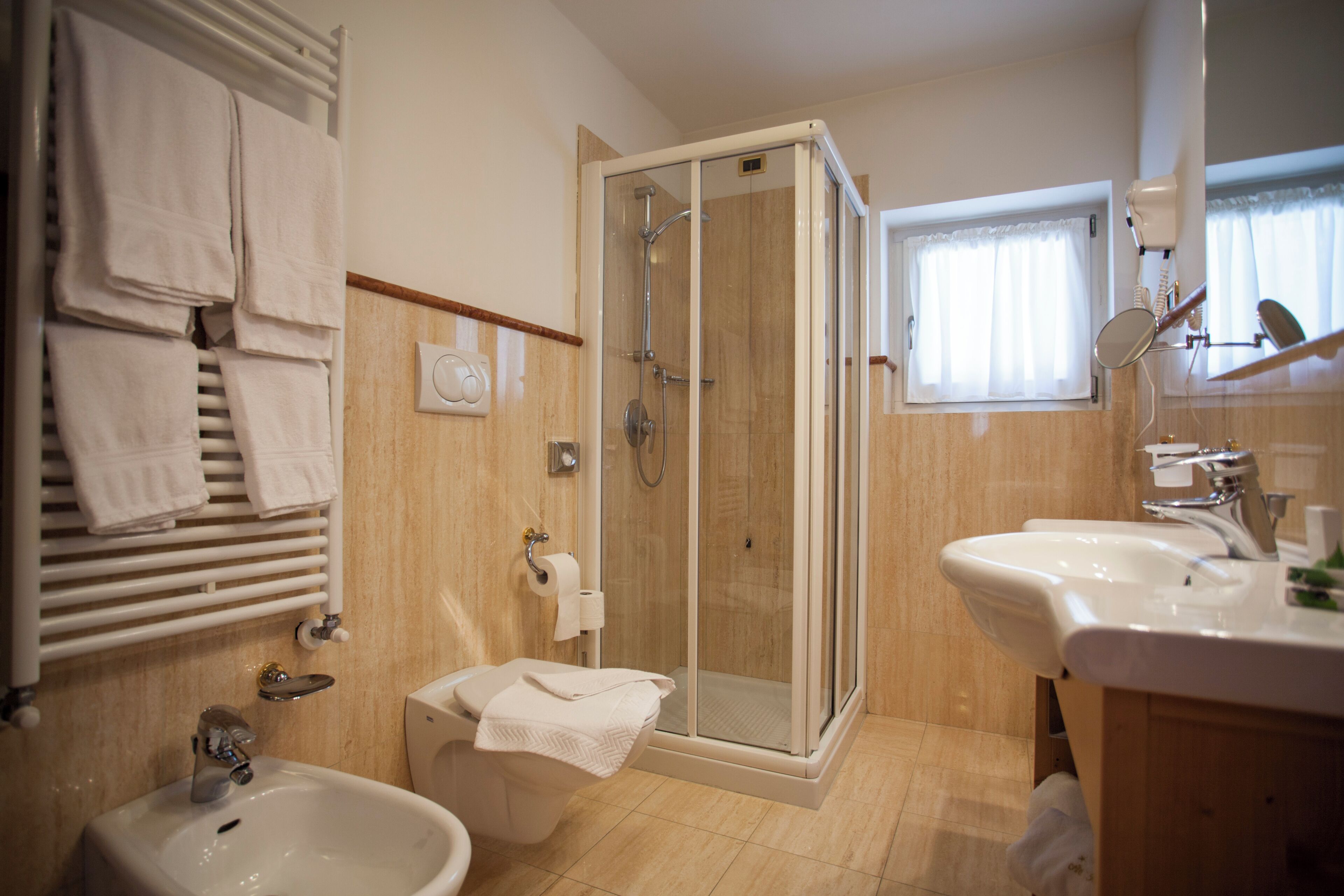 A modern bathroom with a glass-enclosed shower, a white sink, and a toilet.