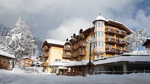A multi-story hotel with balconies, a covered outdoor area, and snow-covered surroundings. - Hotel Chalet all'Imperatore (Tre Ville)