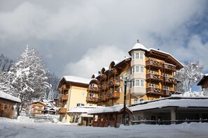 A multi-story hotel with balconies, a covered outdoor area, and snow-covered surroundings. - Hotel Chalet all'Imperatore (Tre Ville)
