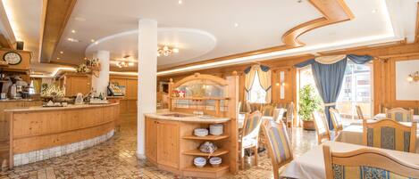 Un restaurante con decoración de madera, piso de baldosas y una barra con vajilla.